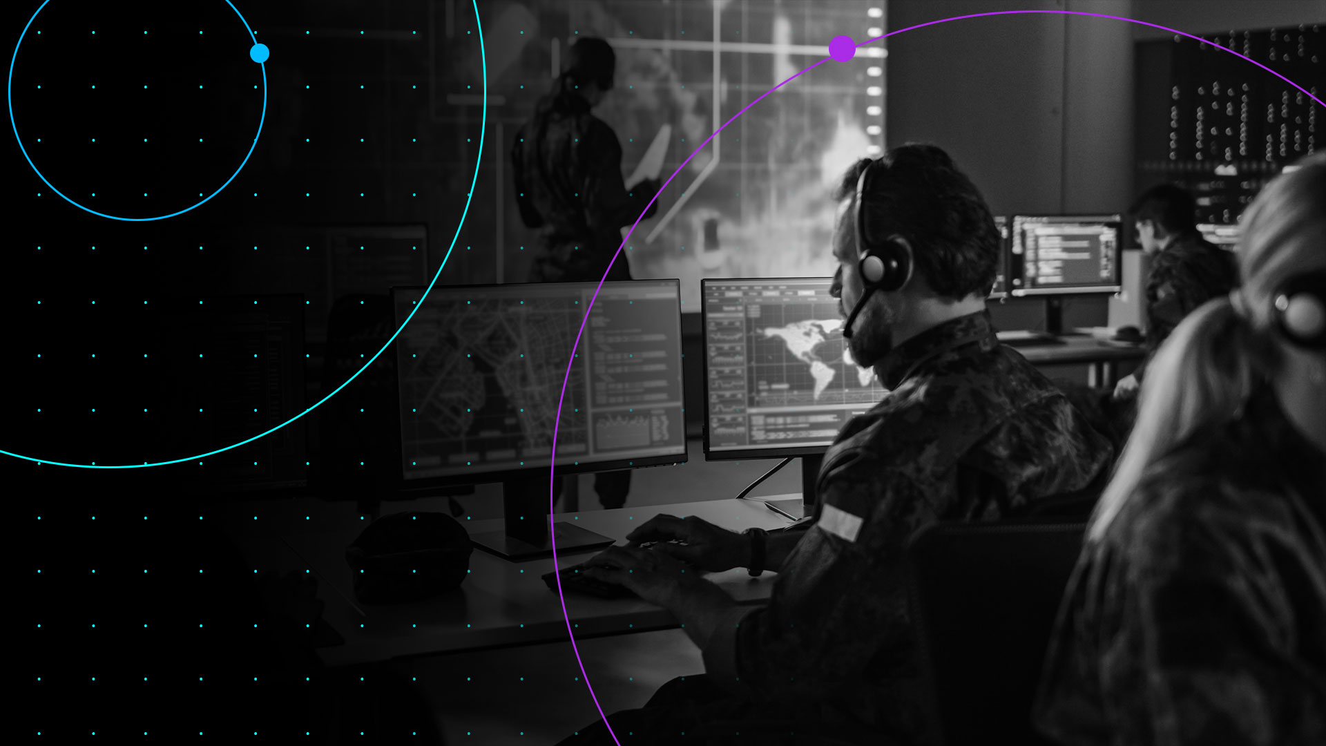black and white image of a military man sitting at a desk with two monitors with gradient dots and orbitals overlay
