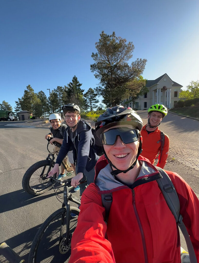 Four men smiling on mountain bikes with helmets