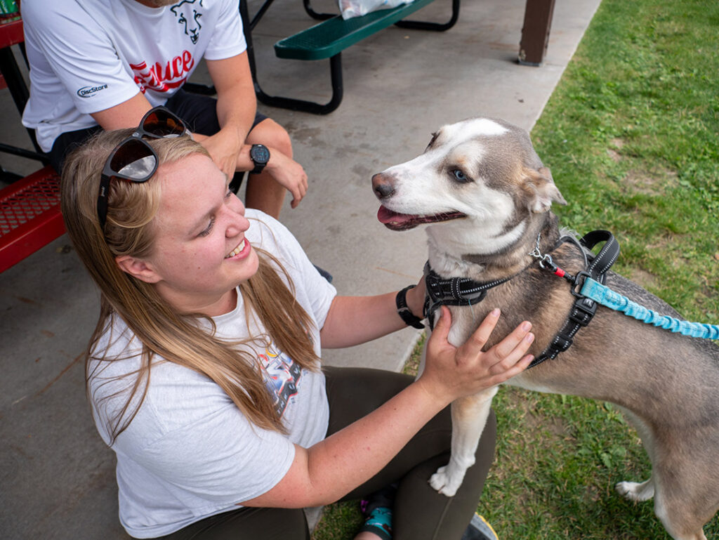 Woman smiling and petting a dog